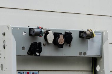 Metal kontrol paneline çoklu elektrik bağlantıları güvenli bir şekilde yerleştirildi. Her konnektör kullanım alanı veya elektronik aygıtlar için özel bir amaca hizmet eder.