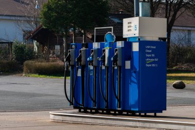 Modern bir yakıt pompa istasyonu dizel ve benzin de dahil olmak üzere çeşitli yakıt seçeneklerine sahiptir. Pompalar düzgünce dizilmiş, kullanılmaya hazır, sakin, banliyö arka planına karşı kurulmuş..