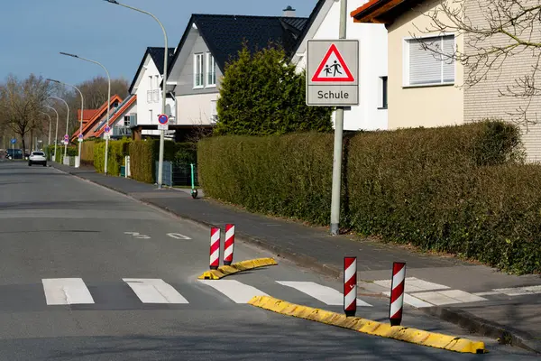 Yoldan geçen bir yaya ikametgah bölgesinde uyarı levhasıyla karşıdan karşıya geçiyor..