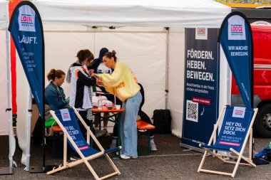 ALMANY, PADERBORN, 77 EASTER RUN, 04-19-2025. Katılımcılar, sağlık ve hareket odaklı yerel girişimleri incelemek üzere bir kabinde toplandılar. Sadece editör kullanımı.