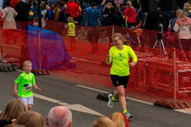 ALMANY, PADERBORN, 77 EASTER RUN, 04-19-2025. Parlak tişörtler giyen katılımcılarla eğlenceli bir koşu gerçekleştirildi. Sadece editör kullanımı.