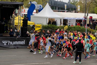 ALMANY, PADERBORN, 77 EASTER RUN, 04-19-2025. Önde futbol oyuncuları olan koşucular başlangıç çizgisine gidiyor. Sadece editör kullanımı.