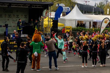ALMANY, PADERBORN, 77 EASTER RUN, 04-19-2025. Çeşitli yaşlardan koşucular, büyük bir kalabalığın alkışladığı canlı bir yarışa katılıyorlar. Sadece editör kullanımı.