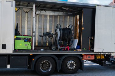 İnşaat karavanında, inşaat sahasında kullanılmak üzere düzenlenmiş kablo makaraları ve makineler de dahil olmak üzere çeşitli araç ve gereçler yer alıyor. 