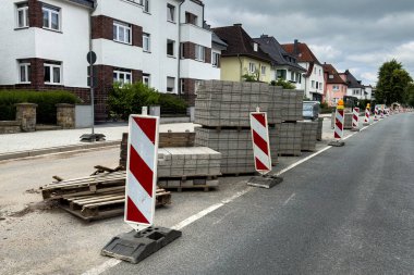 Tahta paletlerin üzerine beton döşeme levhaları yığılmış. Şehir caddesinde yol çalışması