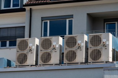 Çağdaş bir binanın çatısına birden fazla klima yerleştirildi..