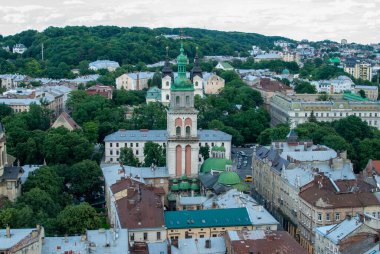 Lviv Ukrayna 'nın pitoresk kentsel manzarasından, çeşitli mimari yapıları ve ağaçlarla çevrili dikkat çekici kuleleri, tarihi cazibesini ve kentsel dokusunu gözler önüne serer..