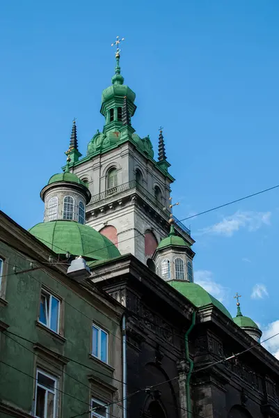 İkonik yeşil kubbeler ve Lviv Ukrayna 'daki Dormition Kilisesi' nin Korniakt Kulesi şehrin tarihi mimarisini ve kültürel mirasını gözler önüne seren açık mavi gökyüzüne karşıdır..
