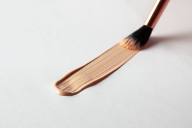 Make up smear foundation smudge drawing by cosmetic brush texture. Liquid foundation swatch close up.