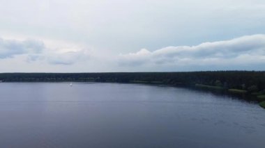 Büyük su deposundaki yelkenli teknesinin havadan görünüşü. İnsanlar, su deposundaki yelkenlide sıcak yaz havasının keyfini çıkarıyorlar.