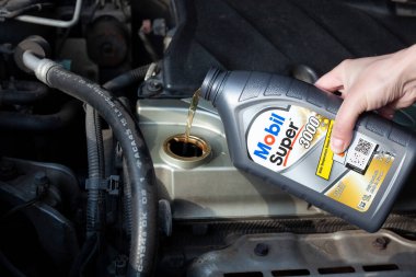Araba motoruna yağ dök, kapat. Mobil Süper Sentetik motor yağı. Ukrayna, Harkiv - 29 Mayıs 2023