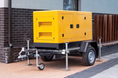 Modern binanın dışında duran acil durum elektrik enerjisi için mobil dizel jeneratörü..