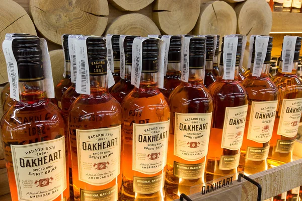 Oakheart spiced rum Bacardi advertisement stand with the illumination and 500 ml rum bottles in a supermarket shelf closeup. Ukraine, Kharkiv - july 20, 2023