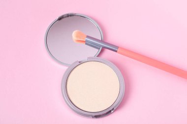 Makyaj fırçası ile güzel bir göz fonu paleti pembe arka plan görünümünde uzanıyor. Makyaj ürünü.