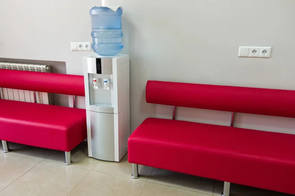 Hospital Reception Area with Refreshing Water Cooler. Welcoming hospital reception area, a modern and hygienic water cooler stands as a symbol of care and comfort.