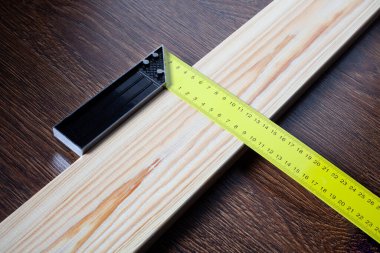 Tahta üzerinde ölçmek için kare cetvel ve kalem. İnşaat konsepti Kapat.