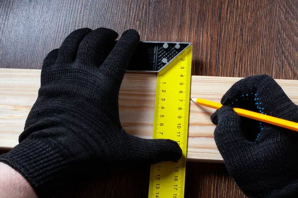carpenter using Square ruler and pencil for measuring on wooden board. construction concept