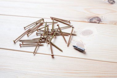 Tahta masadaki vida ve tornavida yığını. Tahta için kendi kendine dokunan vida