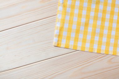 Ahşap arkaplanda sarı kareli peçete.