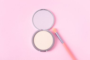 Makyaj fırçası ile güzel bir göz fonu paleti pembe arka plan görünümünde uzanıyor. Makyaj ürünü.