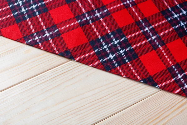 Ahşap arkaplanda kırmızı kareli peçete.