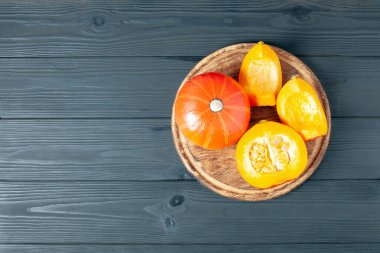 Koyu ahşap arka planda dilimlenmiş balkabağı. Masada kırmızı balkabağı.