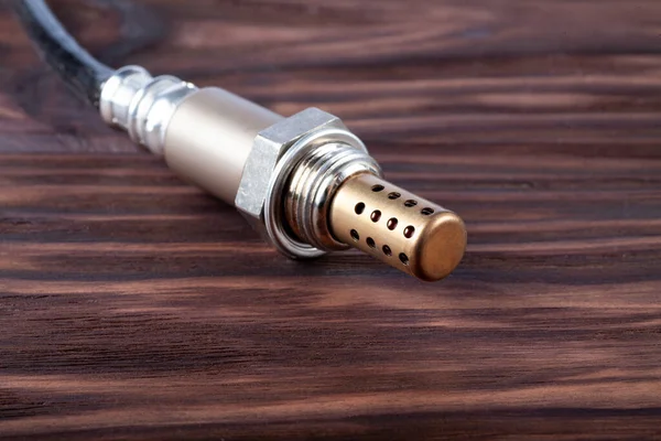 Tahta masadaki benzin ve dizel motorlar için oksijen sensörü. Lambda sondası arabanızın performansını optimize etmek için güvenilir bir bileşendir.