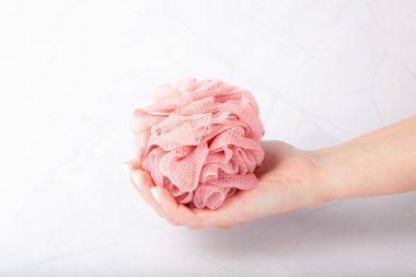 Kadın eli, banyo süngeri tutuyor.