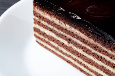 Katmanlı çikolatalı ve kremalı pastaya yakın çekim, zengin tatları ve dokuları olan cazip bir tatlı..