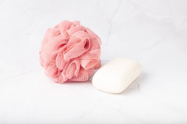 Küresel polyester banyo süngeri ve mermer yüzeyde beyaz sabun. Rahatça banyo yapmak..