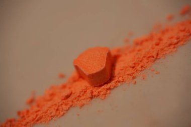 MDMA ecstasy 'li turuncu haplar. Rolex. Arka planı kapatın. Yüksek kaliteli baskılarla güzel sanatlar.