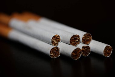 Siyah arka plan tütününe izole edilmiş sigara izmaritinden sigarayı bırakmak kötü alışkanlık olan nikotin müptelası yüksek kalite hazır baskı.
