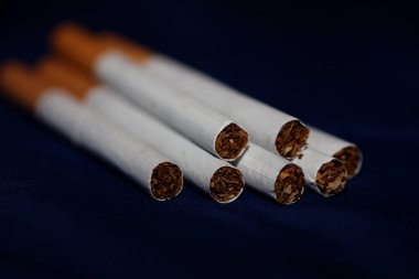 Renkli arka planda pek çok sigara filtre tüplü bir rulo tütünün kapağını kapatır. Ticari sigara yığınları sigara içilmeyen sigara yığınlarının konsept görüntüsü yüksek kaliteli hazır baskıları öldürür.
