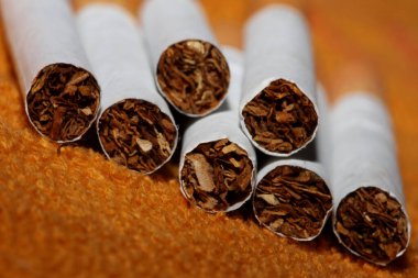Renkli arka planda pek çok sigara filtre tüplü bir rulo tütünün kapağını kapatır. Ticari sigara yığınları sigara içilmeyen sigara yığınlarının konsept görüntüsü yüksek kaliteli hazır baskıları öldürür.