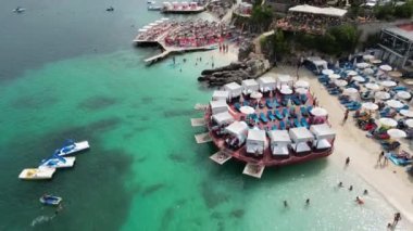 Arnavutluk 'un Ksamil kenti, 12 Ağustos 2023. Güzel 3 ada kristal sularıyla mavi lagünü keşfediyor. Hava aracı görüntülerine göre yaz mevsimi, yüksek kaliteli sinematografi klipleri olabilmek için harika yerlere seyahat ediyor.