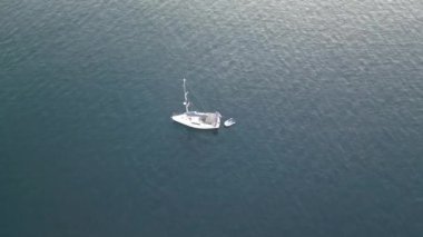 Derin mavi deniz Sarande Koyu 'ndaki rüzgar beyazı yelkenli gemi Arnavutluk yaz tatilinde hava aracı sinematografi klipleri
