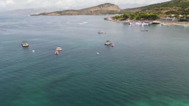 Arnavutluk 'un Ksamil kenti, 12 Ağustos 2023 Kristal sulara sahip 3 ada mavi lagün. Hava aracı görüntüsü yaz mevsiminde çok kaliteli sinematografi klipleri olabilmek için harika yerlere seyahat ediyor.
