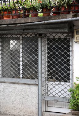 Arnavutluk 'un eski kenti Cirokaster' daki hava durumundan hasar gören eski retro kapı ve pencereler, Balkanlar 'da seyahat ederken yüksek kaliteli, büyük ölçekli hazır stok fotoğrafçılığı baskılarını inceliyor