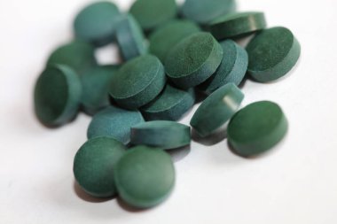 Yeşil yuvarlak haplar medikal spirulina platensisi kapatıyorlar süper yiyecekler modern yüksek kalite, büyük boy hazır baskı yiyorlar.