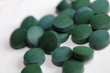 Yeşil yuvarlak haplar medikal spirulina platensisi kapatıyorlar süper yiyecekler modern yüksek kalite, büyük boy hazır baskı yiyorlar.