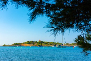 Cala Xinxell, in Ses Illetes, south of the city of Palma, with the Sa Torre island and its tower and some moored boats