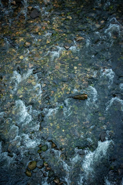 清澈的水流稀少的河流 从上面可以看到岩石 呈暗色 — 图库照片