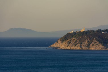 Cape Malabata ve deniz feneri uçurumun tepesinde, Tangier bölgesinde, arka planda güney İspanya 'nın kıyıları ve dağlık silueti.