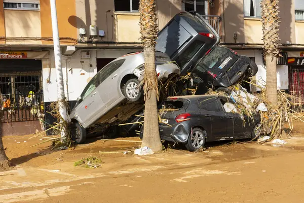 Catarroja, Valencia, İspanya. 31 Ekim 2024 - Çamur ve molozlarla dolu caddedeki selden sonra araçlar birikti.