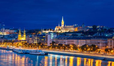 Balıkçı Kalesi 'ndeki Matthias Kilisesi, Macaristan' ın Budapeşte kentinin parlayan ışıklarını yansıtan Tuna Nehri ile geceleyin aydınlandı.