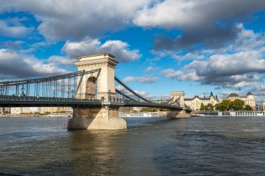 Budapeşte 'deki Zincir Köprüsü' nün Tuna Nehri 'nde usulca yüzen bir teknesiyle gündüz manzarası
