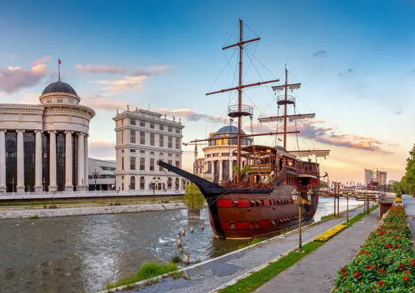 Üsküp şehir merkezindeki Vardar Nehri 'nde gün batımında eski bir gemi şeklinde güzel bir otel. Kuzey Makedonya 'nın başkentinin renkli bahar manzarası.