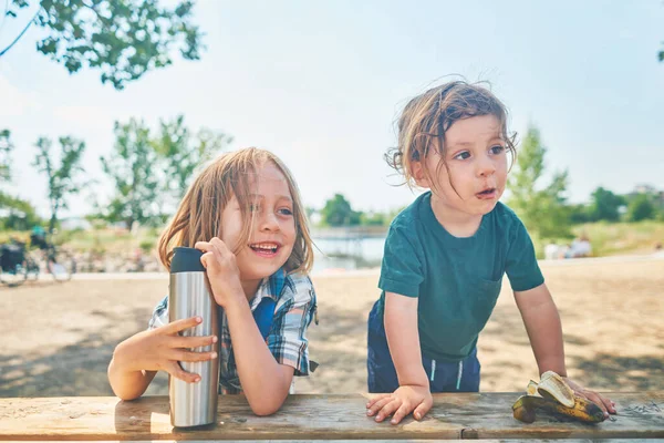 Two Little Boys Relaxing Picnic Table Summer Day Royalty Free Stock Images