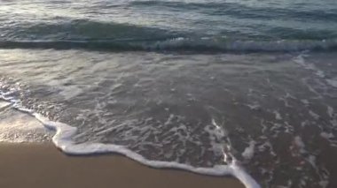 Okyanus dalgaları alacakaranlıkta sahile çarpar..