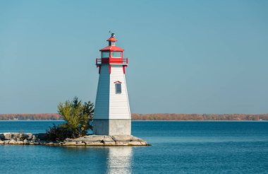 Teneke adadaki gölde gün batımında duran eski deniz feneri manzarası